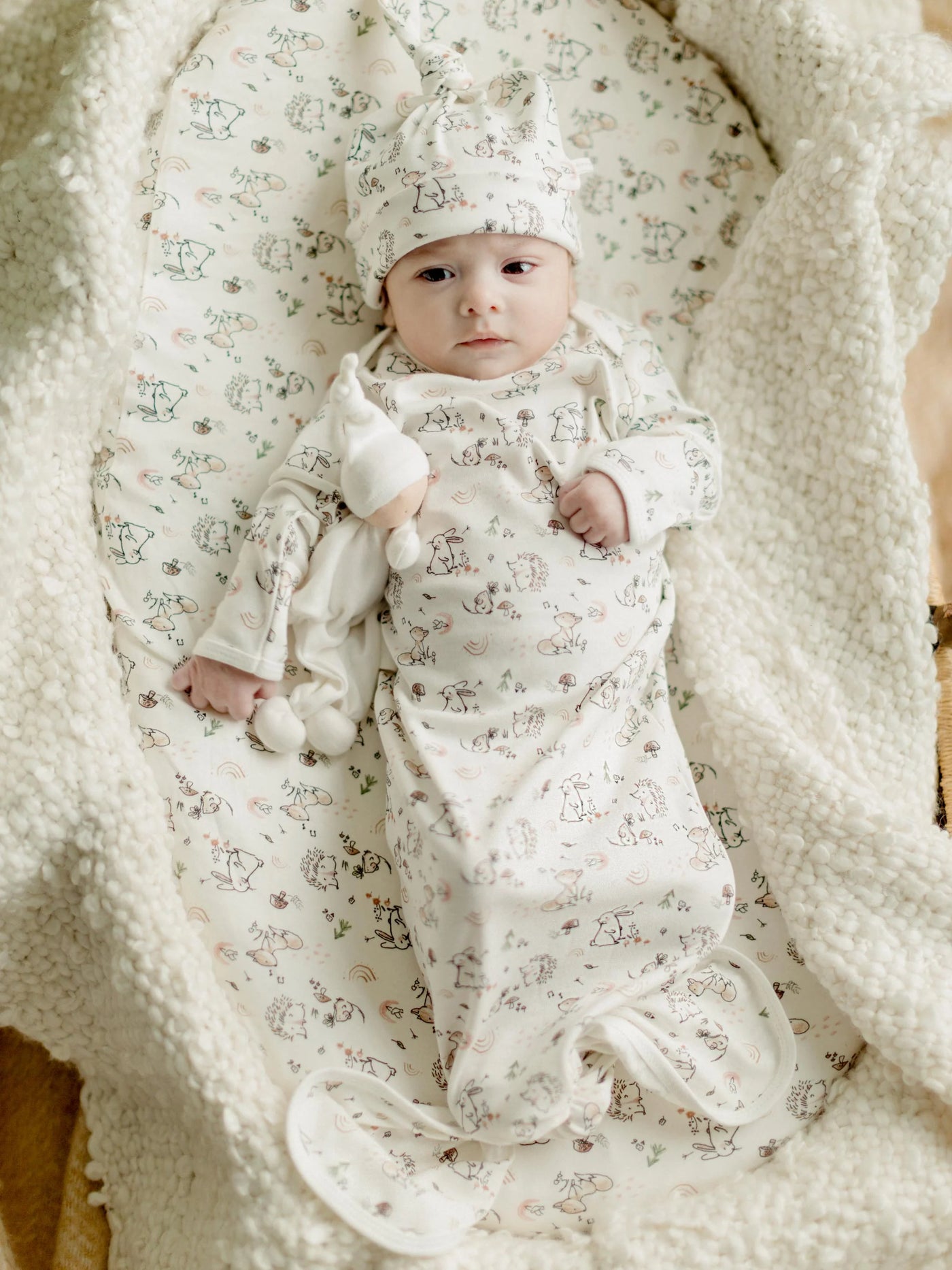baby wearing knotted gown and beanie