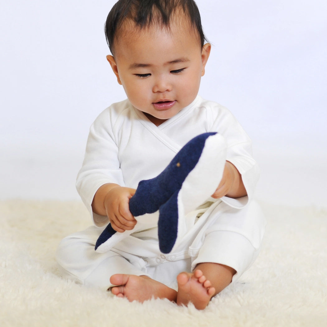 baby playing with organic toy whale