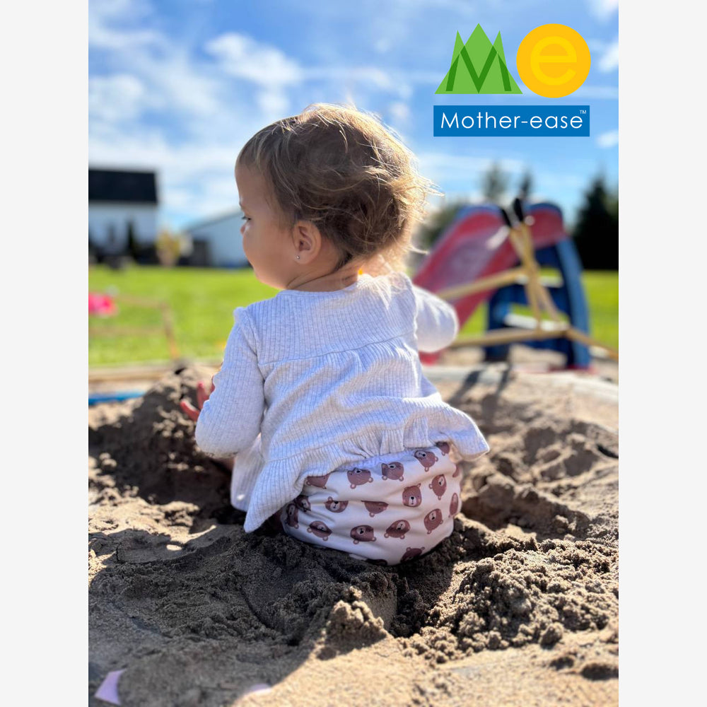 Child playing in a sandbox with 'Mother Ease' logo in the corner