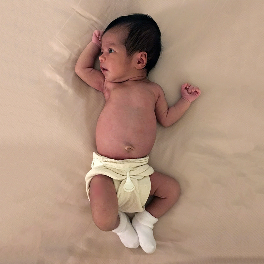 Newborn baby in a muslin flat cloth diaper