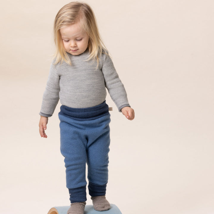 Child wearing blue wool pants 