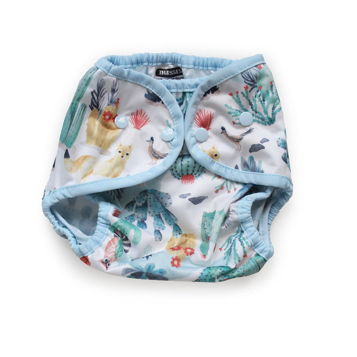 Thirsties Cover reusable cloth diaper with a light blue trim and a white background printed with a colorful Desert Dunes print size Medium