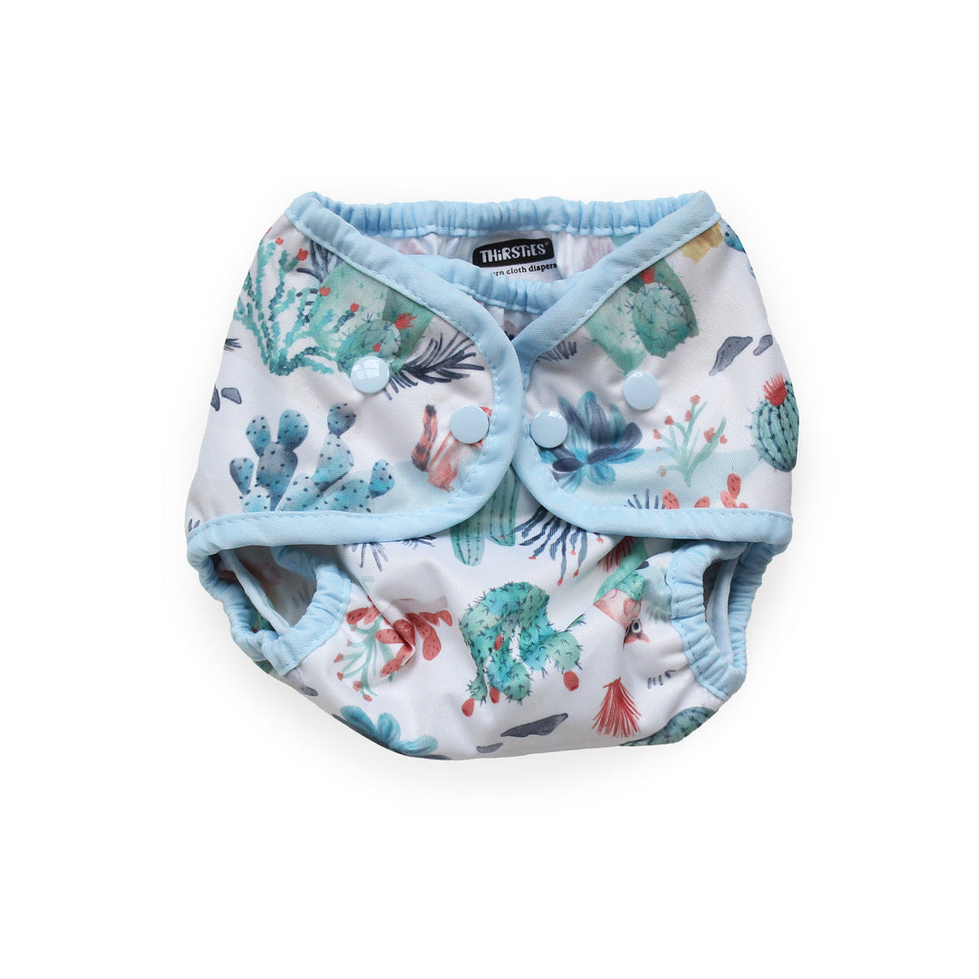 Thirsties Cover reusable cloth diaper with a light blue trim and a white background printed with a colorful Desert Dunes print size small