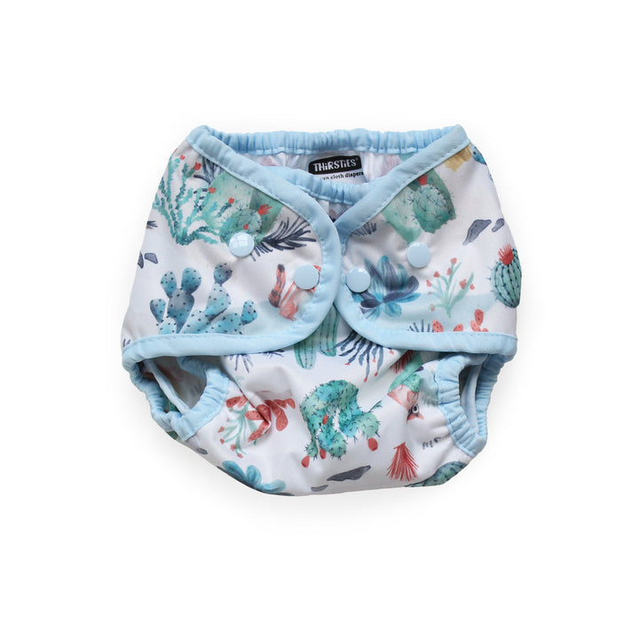 Thirsties Cover reusable cloth diaper with a light blue trim and a white background printed with a colorful Desert Dunes print size small