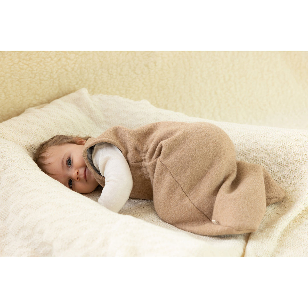 Infant in Disana boiled wool sleeping bag on a knit organic wool blanket babydecke