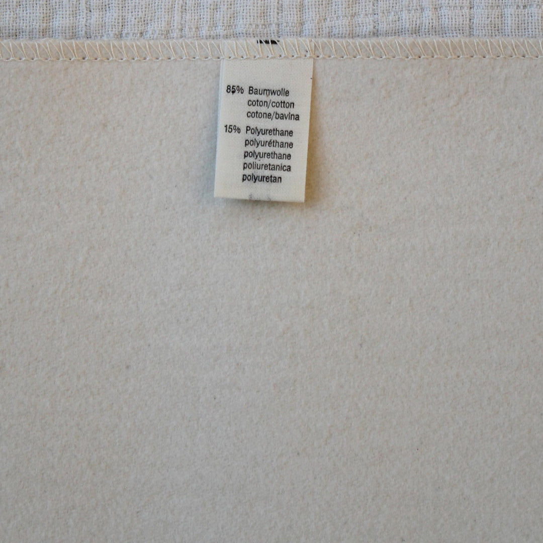 Disana waterproof pad with a label showing material composition
