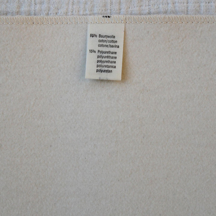 Disana waterproof pad with a label showing material composition