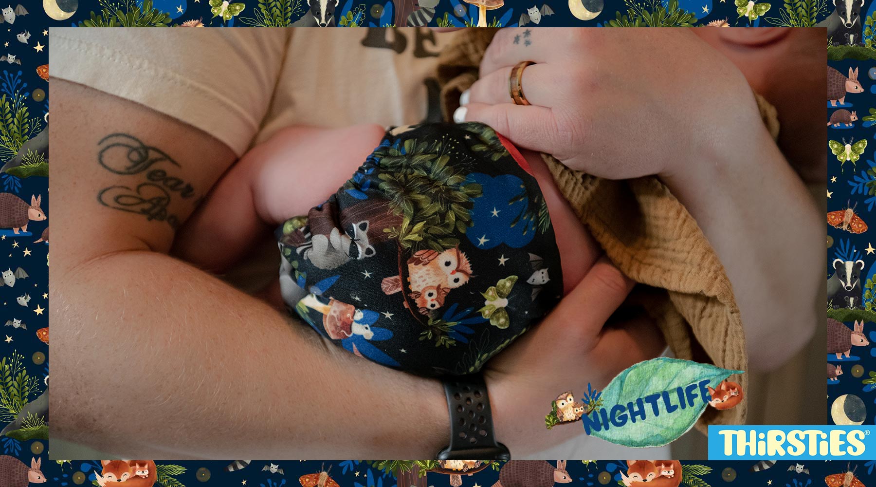 Dad holding newborn baby wearing cloth diaper Thirsties nightlife print