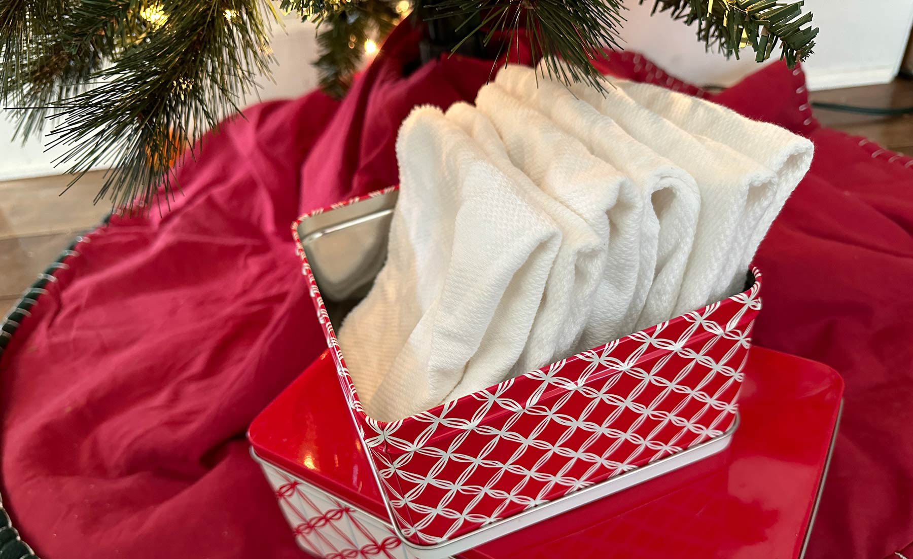 Red and white tissue box under a Christmas tree with cotton baby wipes