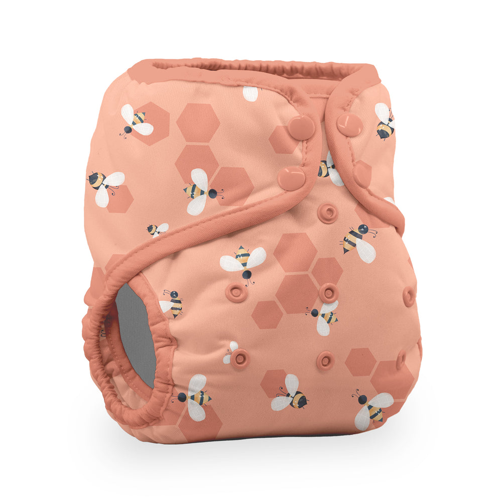 Thirsties natural pocket reusable cloth diaper in a peach color with a pattern of honeycombs and bumblebees Let it Bee print