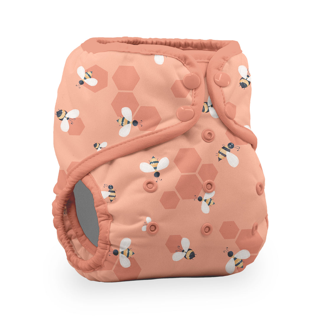 Thirsties natural pocket reusable cloth diaper in a peach color with a pattern of honeycombs and bumblebees Let it Bee print