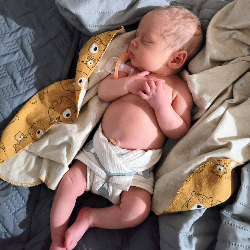 Newborn baby in a cloth diaper Cloth-eez Newborn Muslin flat diaper with a Snappi