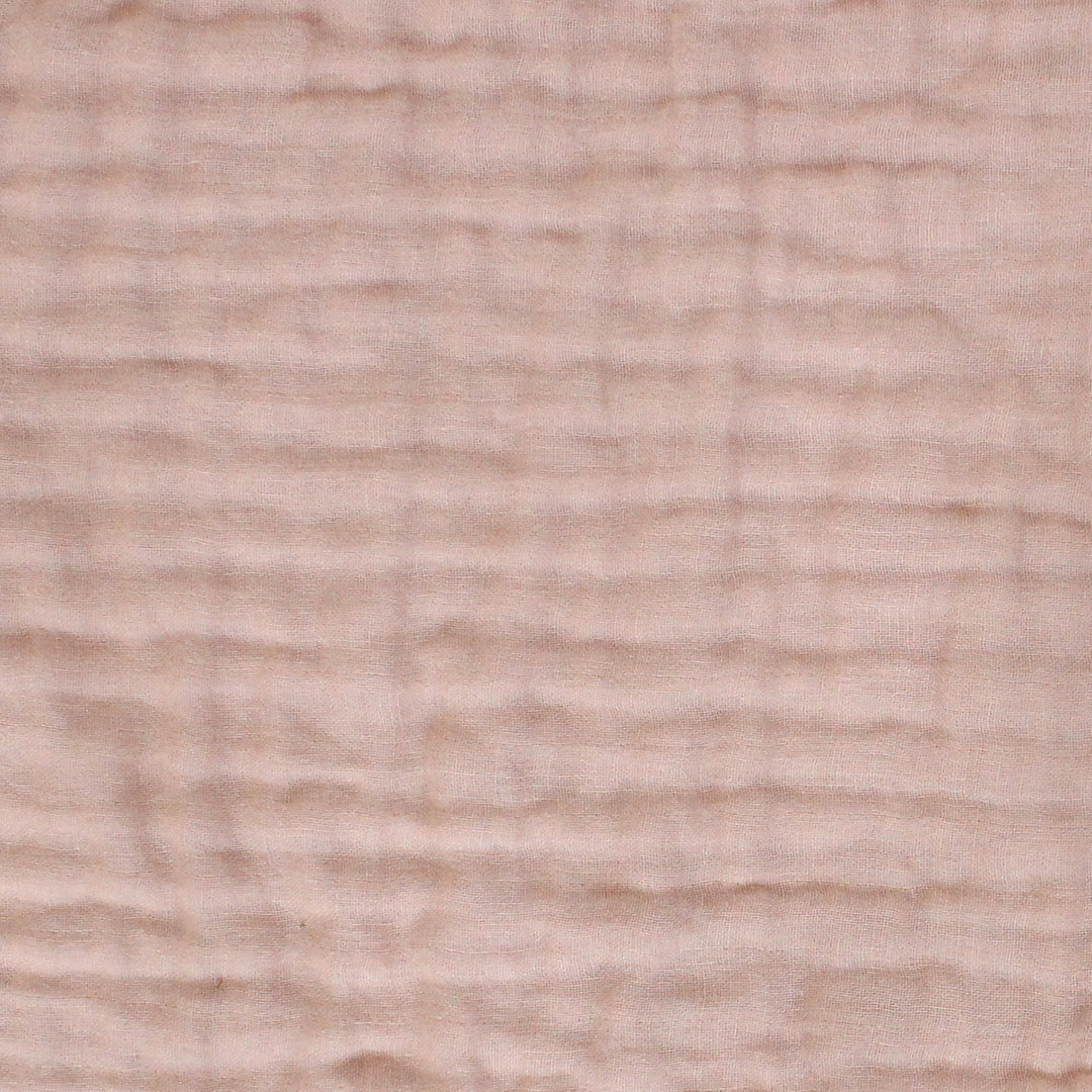 Close-up of a textured crlnkle muslin  fabric surface in color salmon