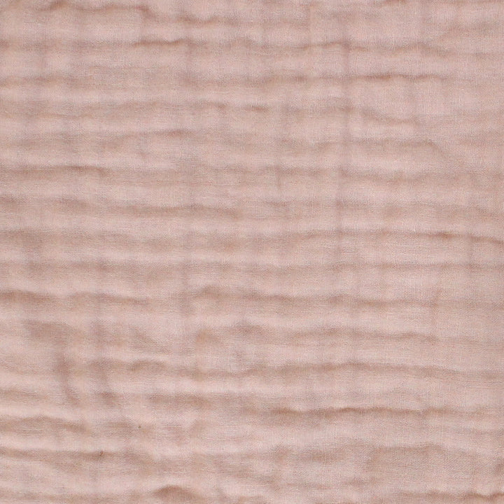 Close-up of a textured crlnkle muslin  fabric surface in color salmon