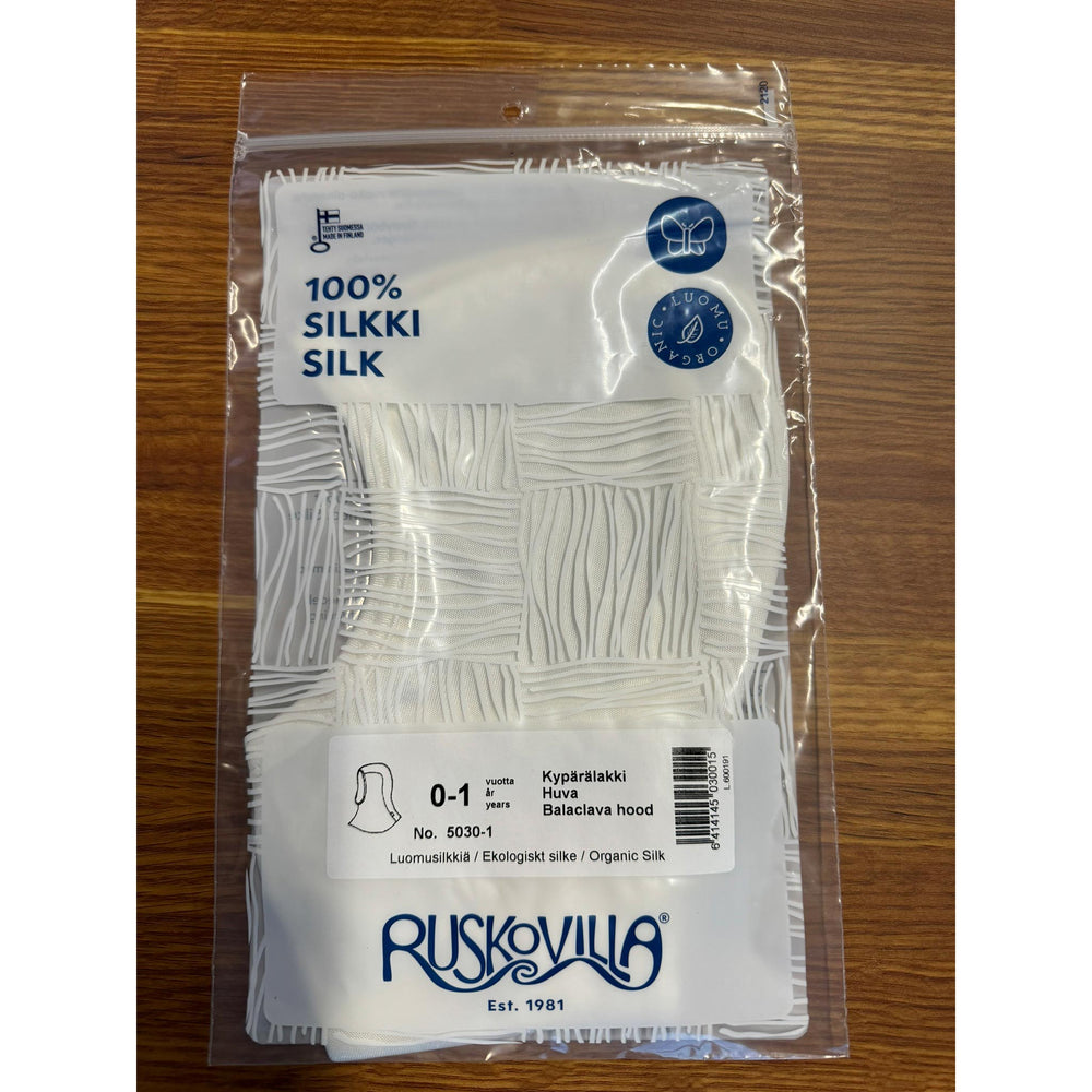 Packaged silk fabric with Ruskovilla branding on a wooden surface