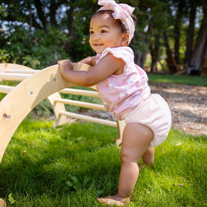 Toddler girl wearing a pink Thirsties natural all in one cloth diaperi
