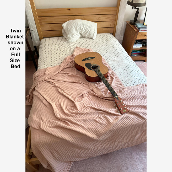 organic muslin blanket shown on a twin size bed