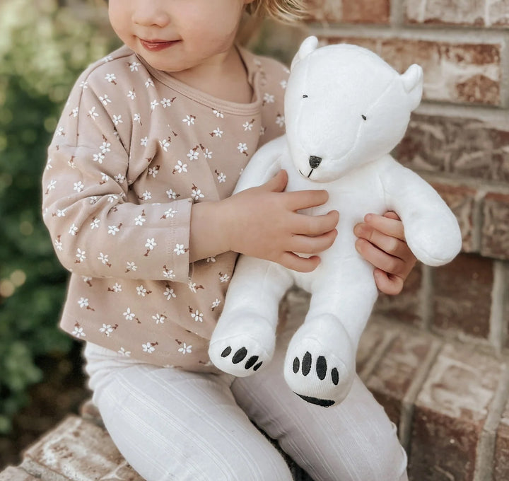 polar bear stuffed toy held by a toddler girl
