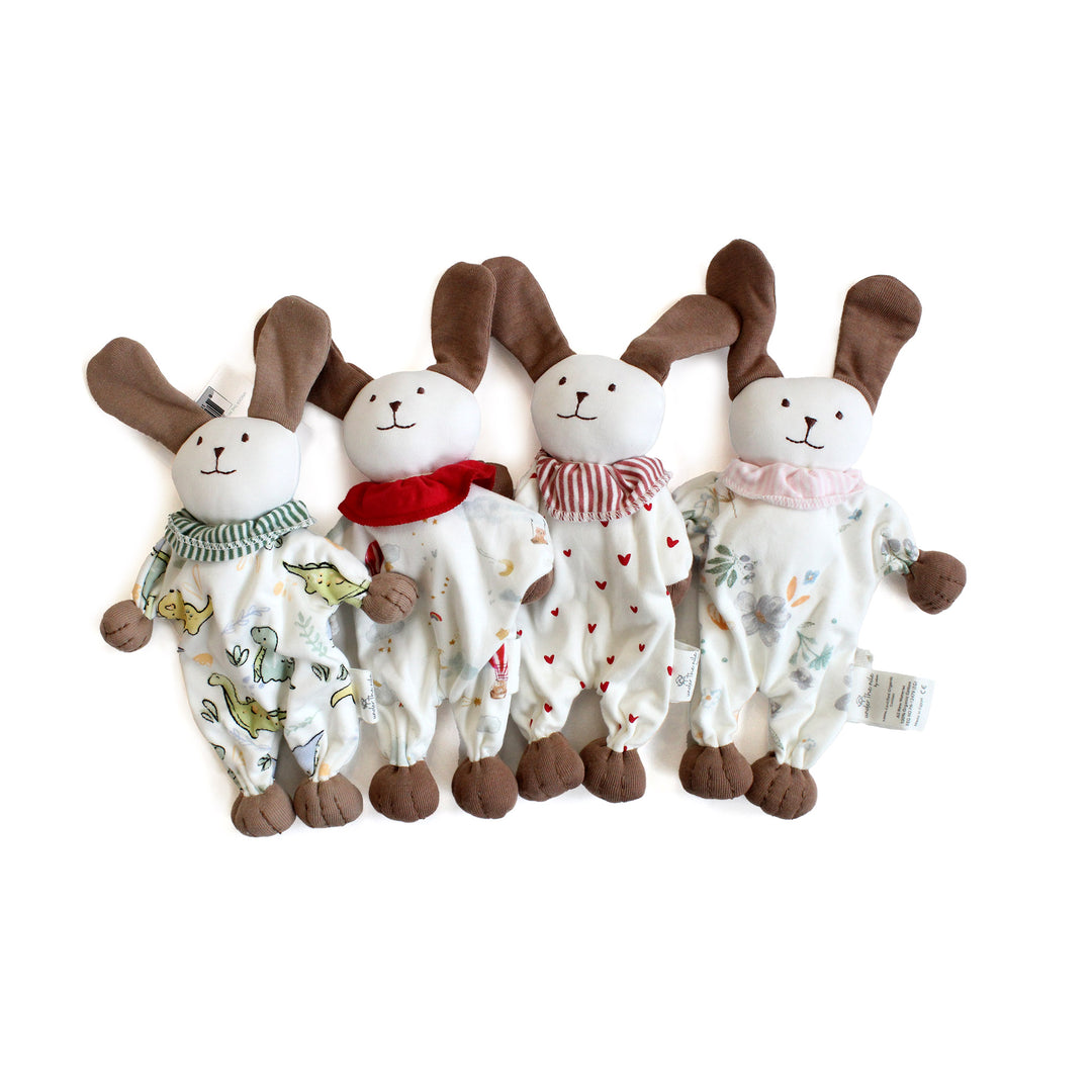 Four plush puppy toys with different patterns and scarves on a white background made of organic cotton for baby