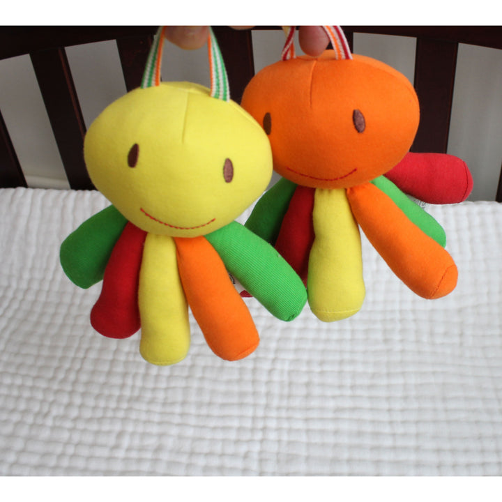 Two organic cotton colorful plush octopus baby toys hanging from fabric handles by Under the Nile 