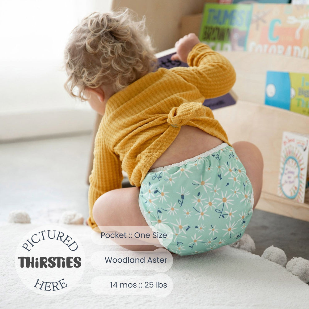 Thirsties natural pocket diaper woodland aster print on a baby